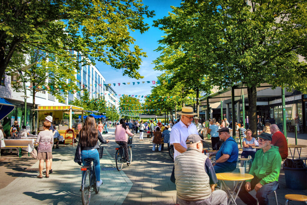 Ulkona kävelykadulla ihmisiä kesäisessä säässä.